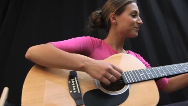 Студентка, играющая на гитаре — стоковое видео