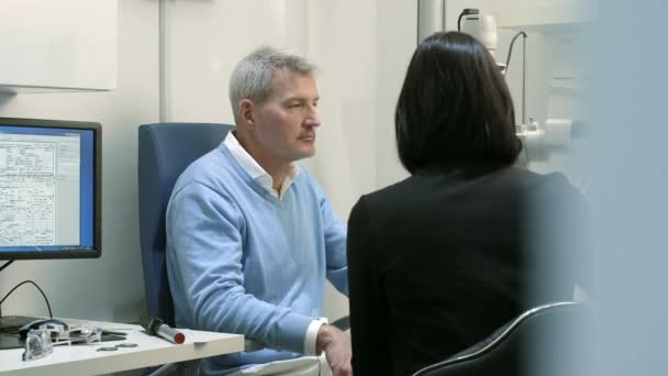 Mannelijke patiënt wordt onderzocht door de vrouwelijke opticien — Stockvideo