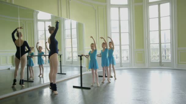 Jóvenes bailarinas estirar y extender en una fila — Vídeos de Stock