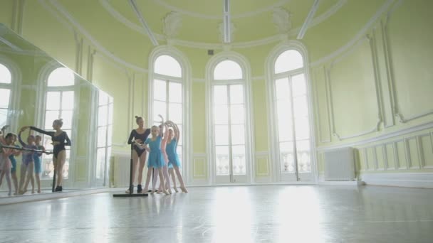 Bailarina de Ballet instruye a tres jóvenes bailarinas — Vídeos de Stock