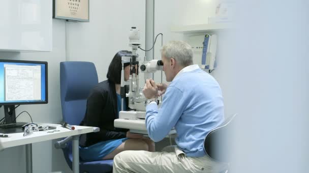 Пациентку осматривает мужчина-оптик — стоковое видео