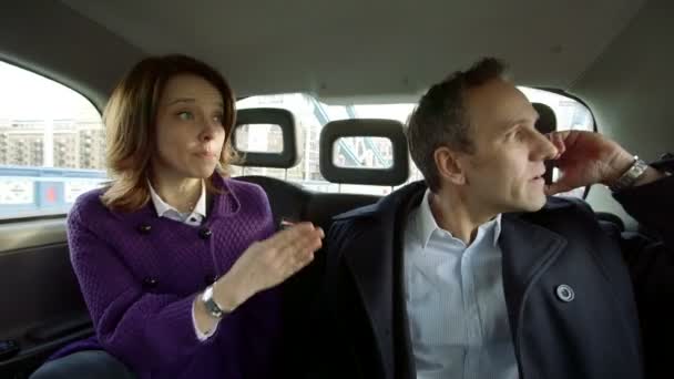 Zakelijke man en vrouw reizen in een taxi — Stockvideo