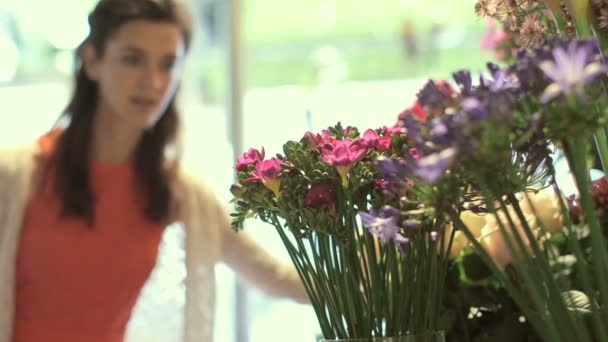 Νεαρή γυναίκα μυρίζοντας τα λουλούδια — Αρχείο Βίντεο