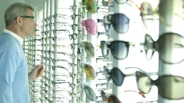Männliche Kundin stöbert in Optikergeschäft — Stockvideo