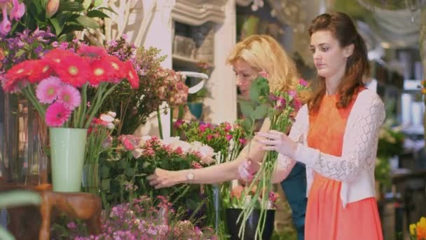 Florista con vistas como aprendiz recogiendo flores — Vídeos de Stock