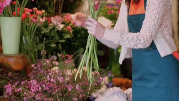 Floristería joven recoge flores — Vídeos de Stock