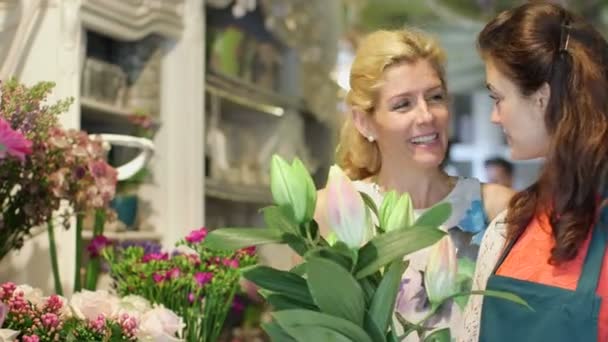 Kwiaciarnia, zbierając kwiaty i Kobieta, decydując się na ich zakup — Wideo stockowe