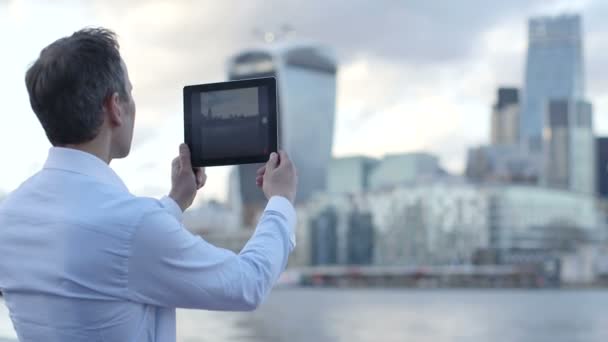 Hombre de negocios toma una foto del paisaje de la ciudad — Vídeo de stock