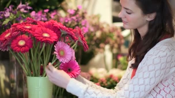 Vrouw bladert en geuren van de bloemen — Stockvideo