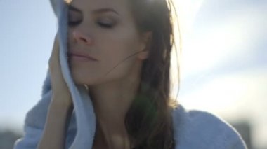 Güzel kadın yüzünü havluyla siliyor 