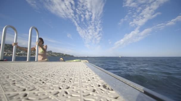 Frau steigt aus Wasser und springt wieder — Stockvideo