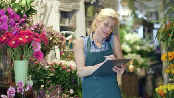 Floristería haciendo una llamada de negocios — Vídeos de Stock