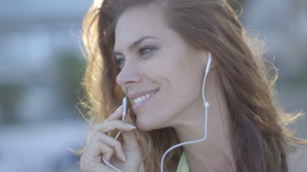 Vrouw met behulp van oortelefoons en praten — Stockvideo