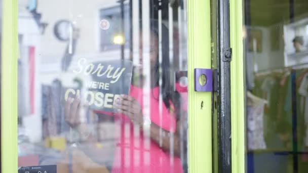 Mujer da la vuelta a un letrero tienda para abrir — Vídeos de Stock