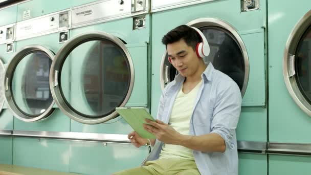 Homem esperando em uma lavanderia — Vídeo de Stock