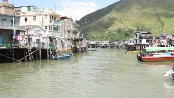 Cabaña inclinada en pueblo pesquero con barco de turismo — Vídeos de Stock