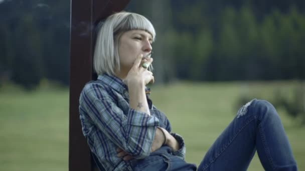 Молодая женщина курит — стоковое видео