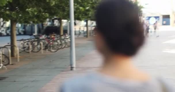 Chica con mochila sonriendo y caminando en la calle — Vídeos de Stock