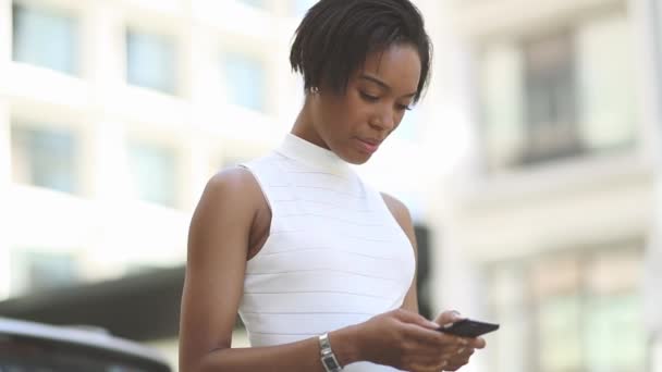 Mujer joven utilizando el teléfono inteligente al aire libre — Vídeos de Stock