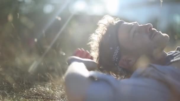 Hombre tomando el sol en la hierba larga — Vídeos de Stock