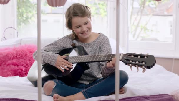 Chica aprendiendo a tocar la guitarra — Vídeo de stock