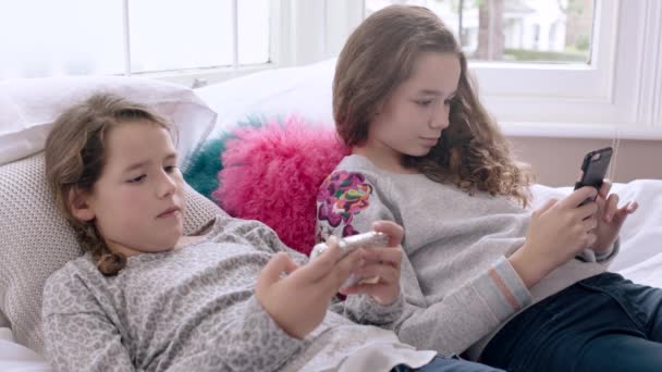 Hermanas mirando sus teléfonos inteligentes — Vídeo de stock