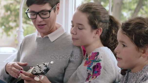 Mamá jugando ukelele a los niños — Vídeo de stock