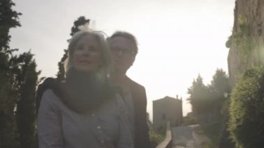 Yaşlı çift günbatımının tadını çıkarıyor.