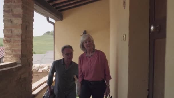 Старшая пара прибывает в квартиру — стоковое видео