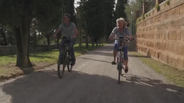 Старшая пара на велосипедах — стоковое видео