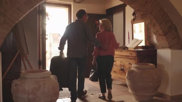 Старшая пара покидает отель — стоковое видео