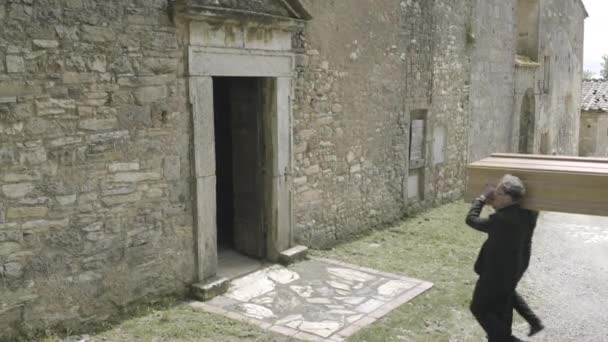 Pallbearers walking into church with coffin — Stock Video