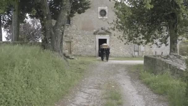 Dragers wandelen naar kerkhof met kist — Stockvideo