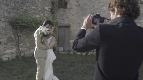 Bruid en bruidegom poseren voor foto — Stockvideo