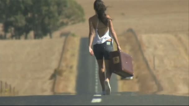 Une jeune femme portant une valise — Video