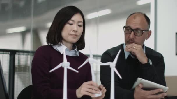 Personnes examinant des modèles d'éoliennes — Video