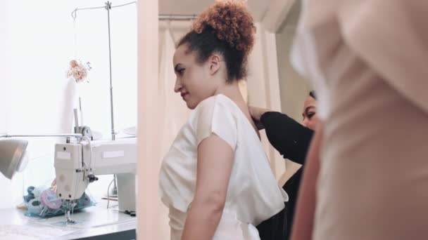 Ung kvinna försöker brudklänning på — Stockvideo
