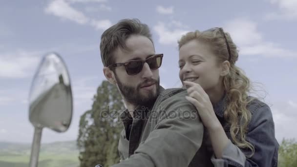 Молодая пара на скутере целуется — стоковое видео