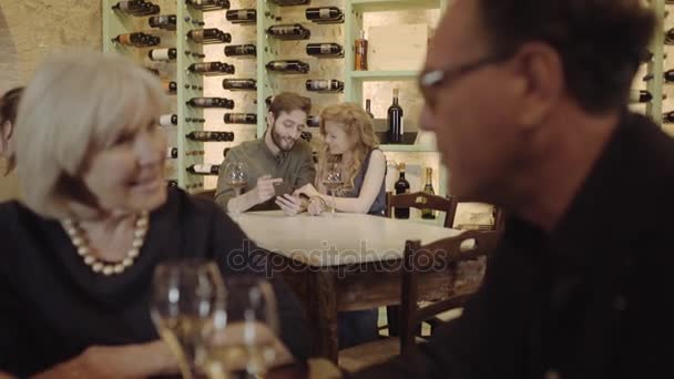 Pareja viendo en el smartphone en el restaurante — Vídeos de Stock