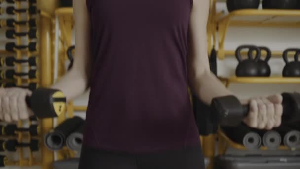 Mujer joven levantando pesas — Vídeo de stock