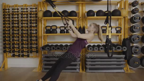 Νεαρή γυναίκα που κάνει άσκηση με trx λουρίδες — Αρχείο Βίντεο