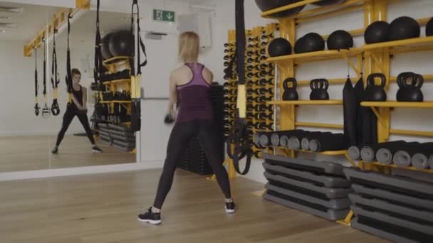 Young woman lifting kettle bell — Stock Video