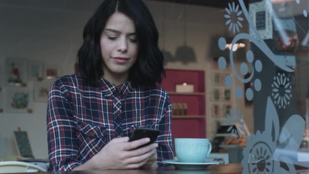 Junge erwachsene Frau schaut aufs Smartphone — Stockvideo