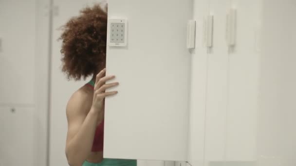 Mladá žena otevírání skříňky v tělocvičně — Stock video