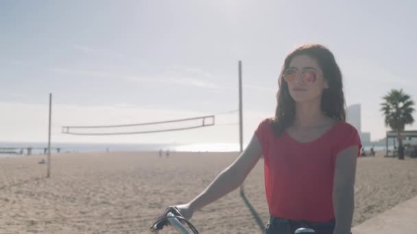 Kadın turist kumsalda Bisiklete binme — Stok video