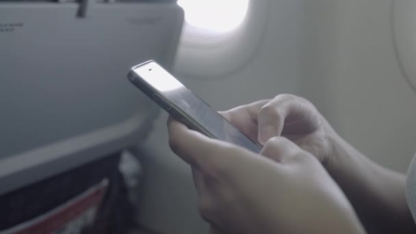 Female on plane with phone — Stock Video