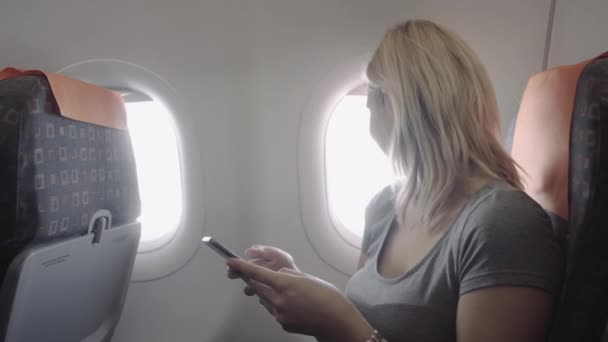 Female on plane with smart phone — Stock Video