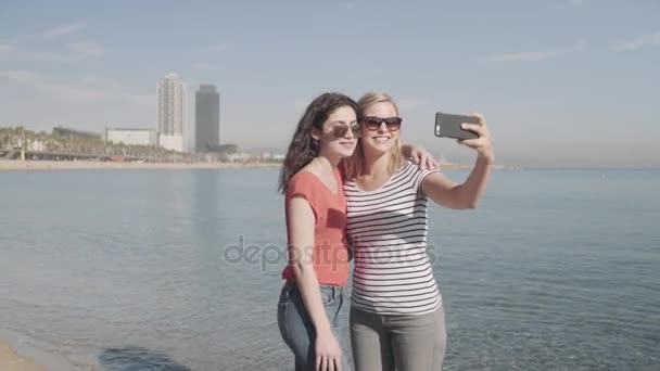 Жінки фотографують себе на пляжі — стокове відео