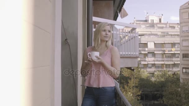 Frau genießt Drink auf Balkon — Stockvideo