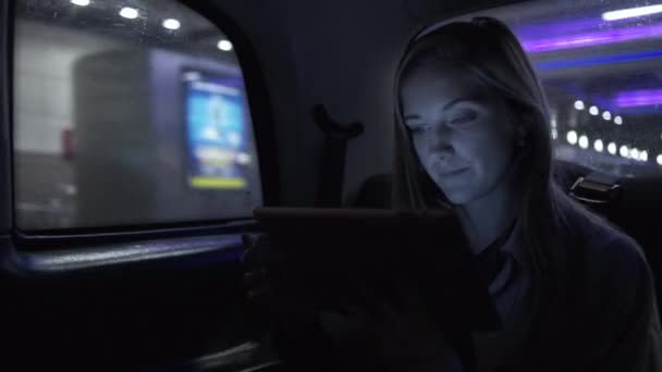 Jovem do sexo feminino em táxi usando tablet — Vídeo de Stock